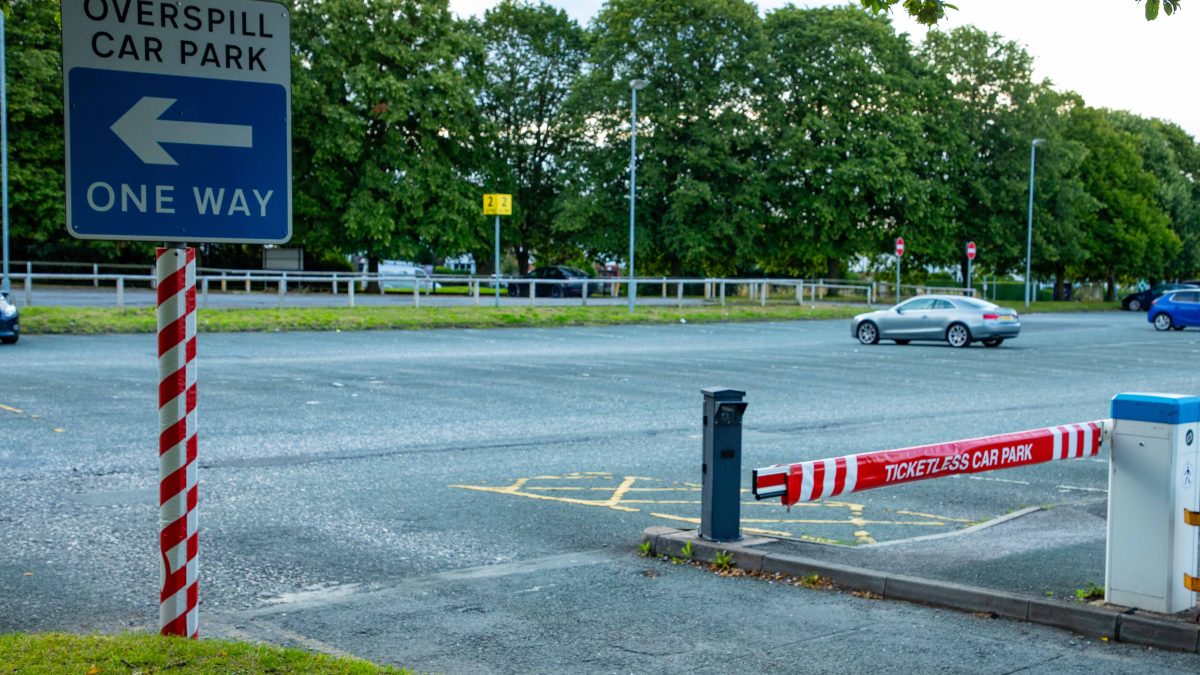 A car park barrier with a protective cover to reduce risk to pedestrians