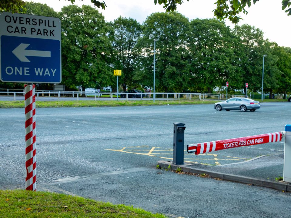 A car park barrier with a protective cover to reduce risk to pedestrians