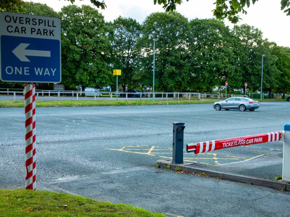 A car park barrier with a protective cover to reduce risk to pedestrians